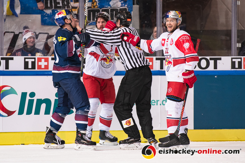 John Hughes (EC Red Bull Salzburg) amüsiert sich über die Auseinandersetzung von Jakob Mayenschein (EHC Red Bull Muenchen) mit Martin Stajnoch (EC Red Bull Salzburg) im Halbfinal-Hinspiel der Champions Hockey League zwischen dem EHC Red Bull München und dem EC Red Bull Salzburg (Österreich) am 08.01.2019.