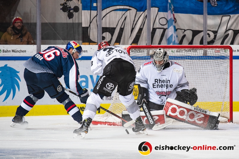 Austin Madaisky (Koelner Haie) und Hannibal Weitzmann (Torwart, Koelner Haie) verhindern einen Treffer durch Andreas Eder (EHC Red Bull Muenchen) in der Hauptrundenbegegnung der Deutschen Eishockey Liga zwischen dem EHC Red Bull München und den Kölner Haien am 14.12.2018.