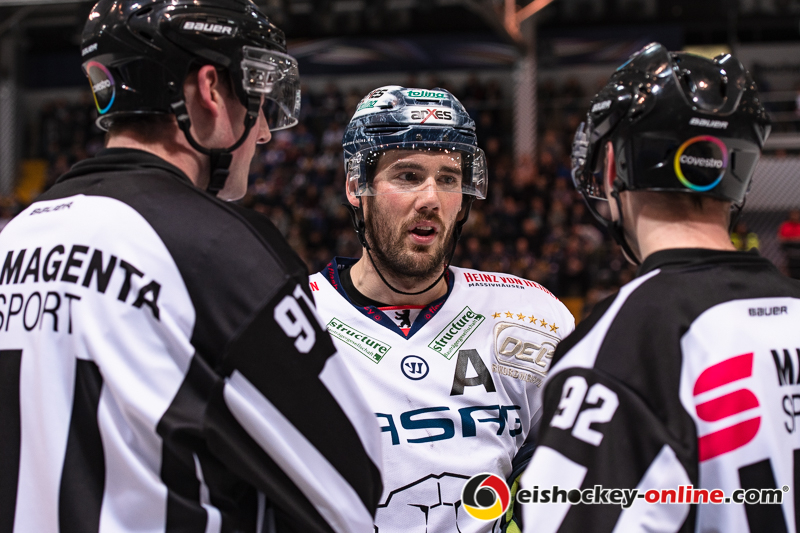 James Sheppard (Eisbaeren Berlin) im Gespraech mit Linesman Tobias Schwenk und Linesman Kilian Hinterdobler in der 3. Viertelfinalbegegnung in den Playoffs der Deutschen Eishockey Liga zwischen dem EHC Red Bull München und den Eisbären Berlin am 17.03.2019.